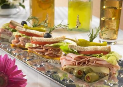 Corporate catering sandwich bar with bread, ham olives with toothpicks holding it together.