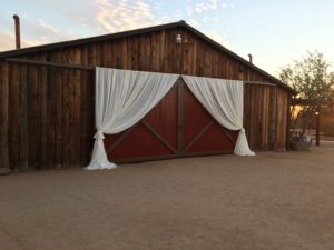 brown barn with red doors prepared for a rustic wedding